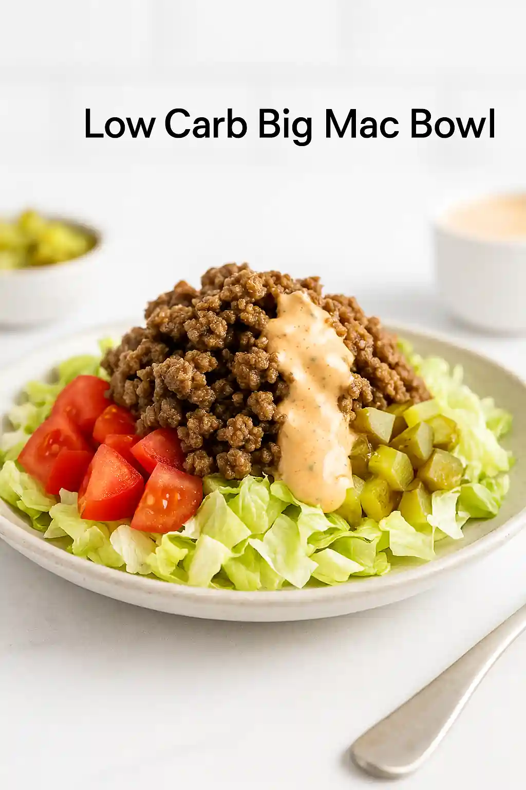 A bright, modern kitchen photo of a plated Big Mac Bowl variation with lettuce, seasoned beef, pickles, cheese, and sauce, styled minimally with natural lighting.
