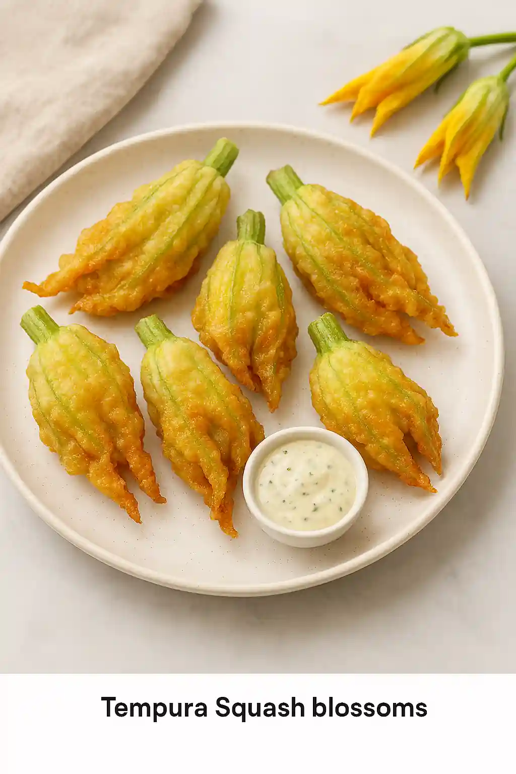 Tempura-fried squash blossoms and stuffed blossoms plated with dipping sauce, showcasing crispy texture and vibrant colors in bright natural kitchen lighting.